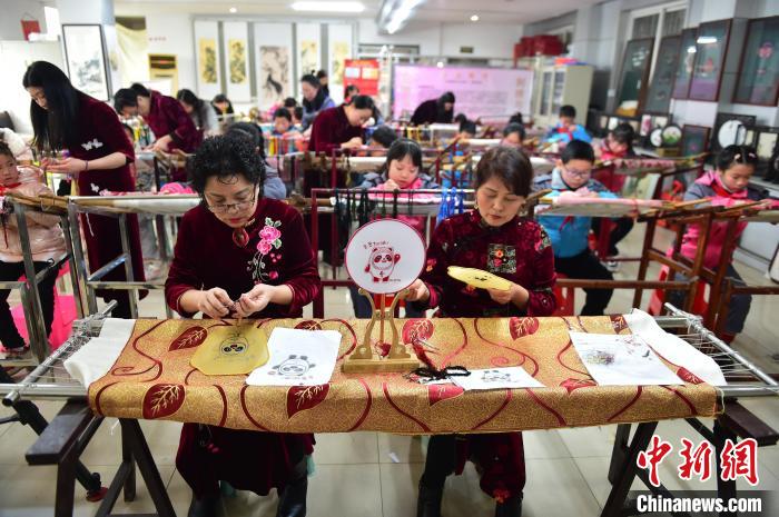 江西省級(jí)非遺豫章繡傳承人手把手指導(dǎo)小學(xué)生繡制2022年北京冬奧會(huì)吉祥物“冰墩墩”形象?！∮髟屏?攝