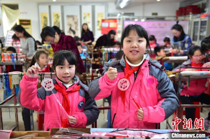 圖為小學(xué)生展示繡制好的2022年北京冬奧會(huì)吉祥物“冰墩墩”形象?！∮髟屏?攝
