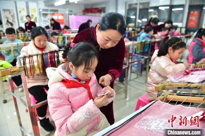 江西省級(jí)非遺豫章繡傳承人手把手指導(dǎo)小學(xué)生繡制2022年北京冬奧會(huì)吉祥物“冰墩墩”形象?！∮髟屏?攝