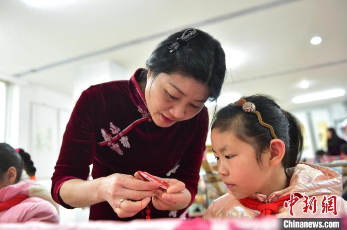 江西省級(jí)非遺豫章繡傳承人手把手指導(dǎo)小學(xué)生繡制2022年北京冬奧會(huì)吉祥物“冰墩墩”形象?！∮髟屏?攝
