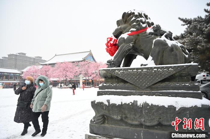 2月13日，民眾在呼和浩特市大召廣場雪中漫步?！⑽娜A 攝