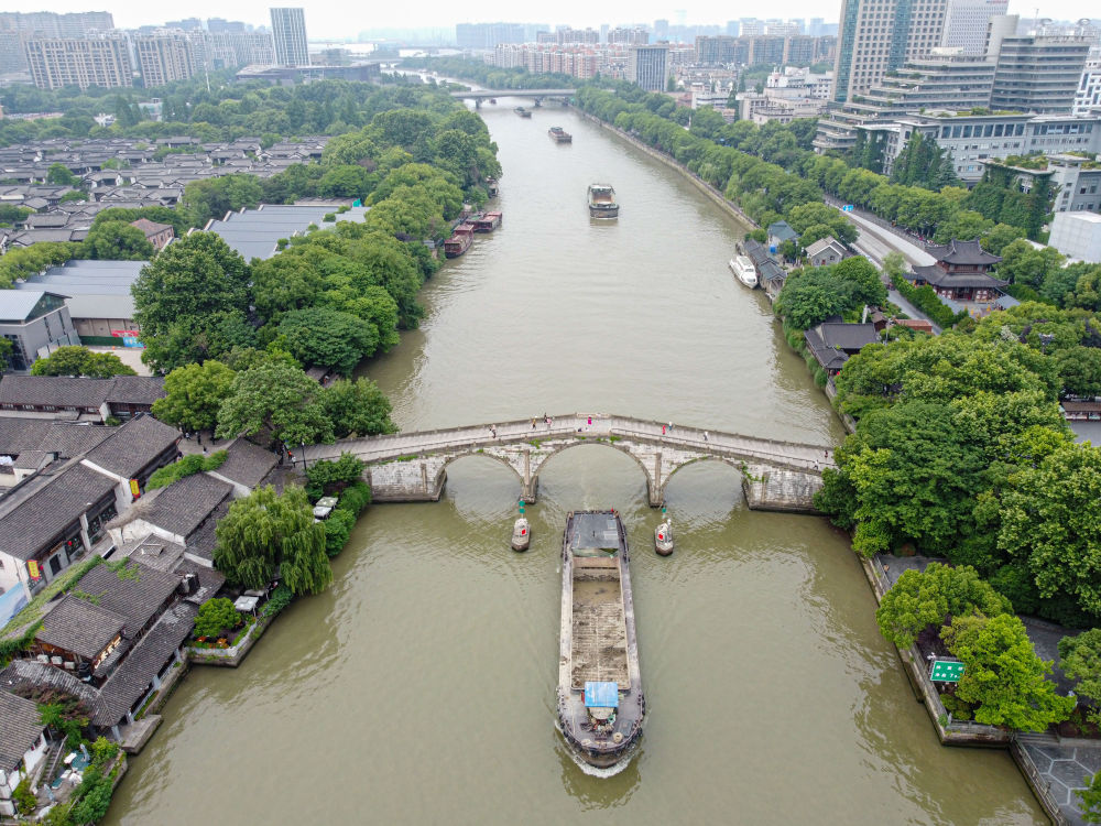 5月27日，一艘貨船駛過京杭大運(yùn)河南端標(biāo)志建筑杭州拱宸橋。(無人機(jī)照片)新華社記者江漢 攝