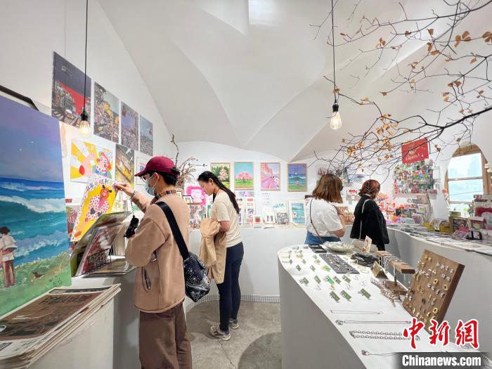 圖為藝術品商店內，顧客挑選插畫作品?！＄婌?攝