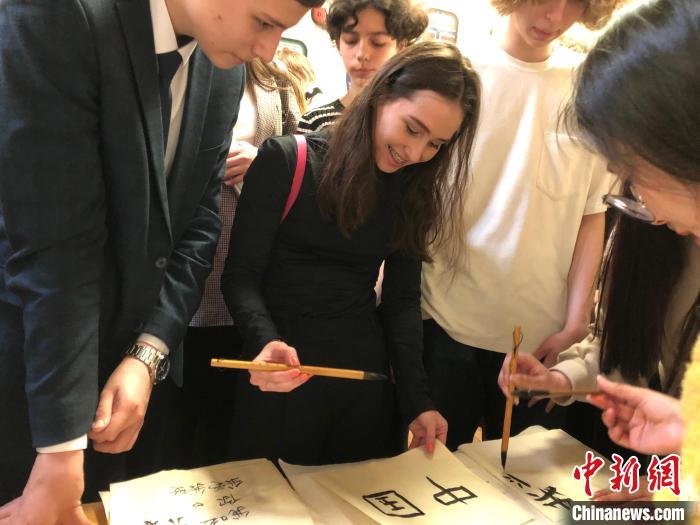 4月21日，莫斯科國立語言大學(xué)孔子學(xué)院附屬中學(xué)舉辦“國際中文日”活動，學(xué)生們學(xué)寫漢字?！∧箍茋⒄Z言大學(xué)孔子學(xué)院 供圖