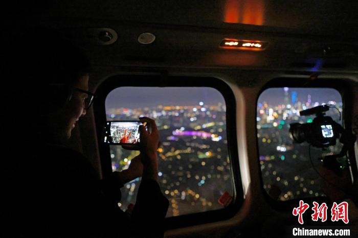 6月3日晚，游客乘坐上海新空直升機有限公司直升機開啟鳥瞰黃浦江空中圓夢之旅，并用手機拍攝城市夜景?！∫罅⑶?攝