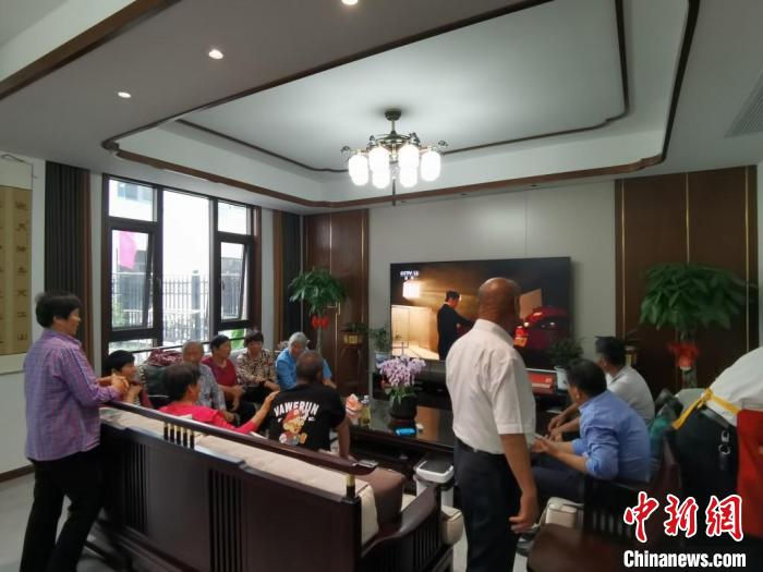 親友們集中在費(fèi)俊龍家中觀看返程的視頻?！＄娚?攝