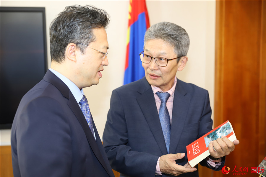 其米德策耶（右一）向李峙介紹翻譯成果。人民網記者 霍文攝