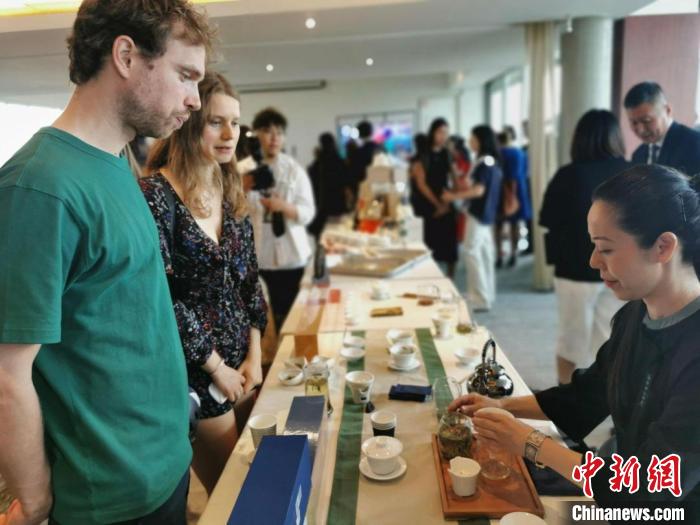 現(xiàn)場觀眾觀看中國展臺茶藝表演、了解茶文化。　靖樹 攝