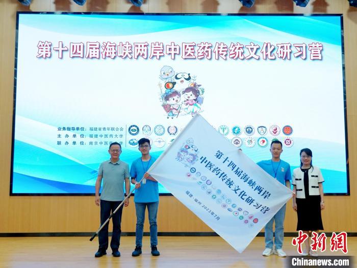 共青團(tuán)福建省委副書(shū)記吳雪(右一)、福建中醫(yī)藥大學(xué)黨委副書(shū)記林羽(左一)為兩岸學(xué)生代表頒授營(yíng)旗?！≡S燁婷 攝