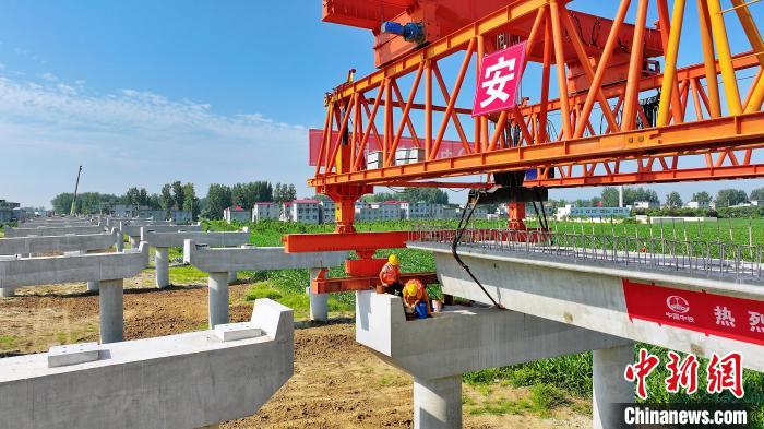 長25米重80噸的箱梁平穩(wěn)、精準地落在S314分離式立交橋25號和26號墩上?！⒂癫?攝