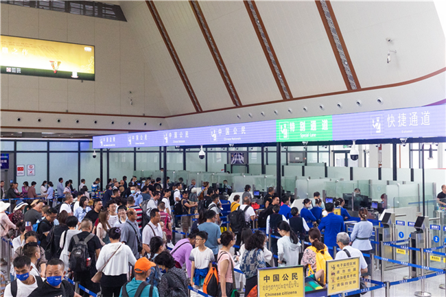 7月22日，乘坐中老鐵路國(guó)際旅客列車的旅客在磨憨邊檢大廳排隊(duì)候檢。衛(wèi)海林 攝