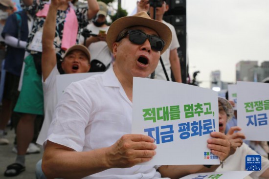 7月22日，在韓國(guó)首爾，人們手舉標(biāo)語(yǔ)參與反戰(zhàn)游行。新華社發(fā)（楊暢 攝）