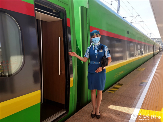 趙瑩靜站在“復(fù)興號”國際旅客列車車廂門口歡迎旅客上車。人民網(wǎng) 杜明明攝