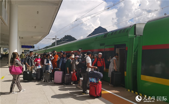 乘坐中老鐵路國際旅客列車的旅客在老撾瑯勃拉邦站排隊(duì)上車。人民網(wǎng)記者 杜明明攝