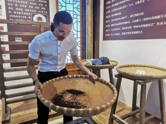 2023“一帶一路”媒體合作論壇聯(lián)合采訪團(tuán)團(tuán)員在非遺文化展示館體驗(yàn)中藥炮制技藝。（本報記者 黃超攝）