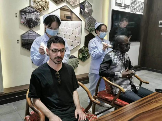 2023“一帶一路”媒體合作論壇聯(lián)合采訪團(tuán)團(tuán)員在九牛草展示館體驗(yàn)艾灸。（本報記者 黃超攝）