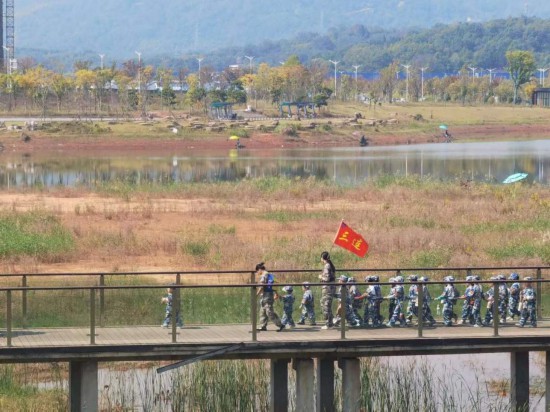 　　10月24日，秋游的幼兒園小朋友在老師帶領(lǐng)下走在清水塘公園里的木橋上。本報記者 常雯宜攝