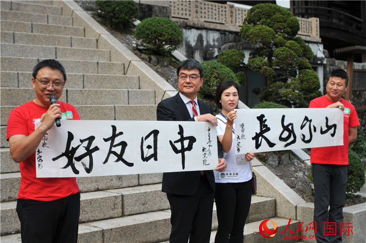 東京中國文化中心主任羅玉泉展示其為本次活動書寫的題詞“中日友好，山高水長”。人民網(wǎng) 蔣曉辰攝