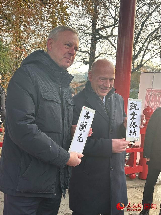 柏林市長韋格納（右）、動(dòng)物園監(jiān)事會(huì)主席布魯克曼（左）手持中國文化中心工作人員現(xiàn)場手書的中文名字。人民網(wǎng)記者 徐馨攝