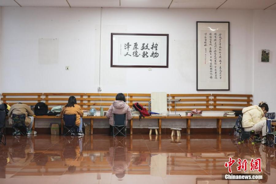 資料圖：幾位考研學(xué)生在南昌大學(xué)教學(xué)樓的公共空間復(fù)習(xí)備考。劉力鑫 攝