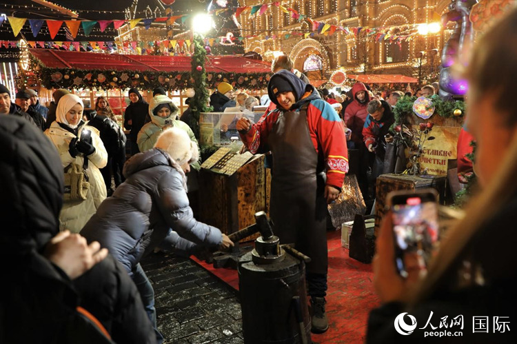 游客在新年集市上體驗(yàn)制作紀(jì)念幣。人民網(wǎng)記者 隋鑫攝