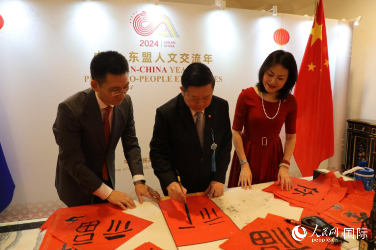 東盟秘書長高金洪（中）在活動現(xiàn)場寫福字。人民網(wǎng)記者曹師韻攝