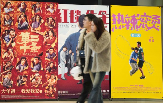 這是2月17日，在沈陽一家影院，觀眾從海報前經(jīng)過。新華社記者李鋼攝