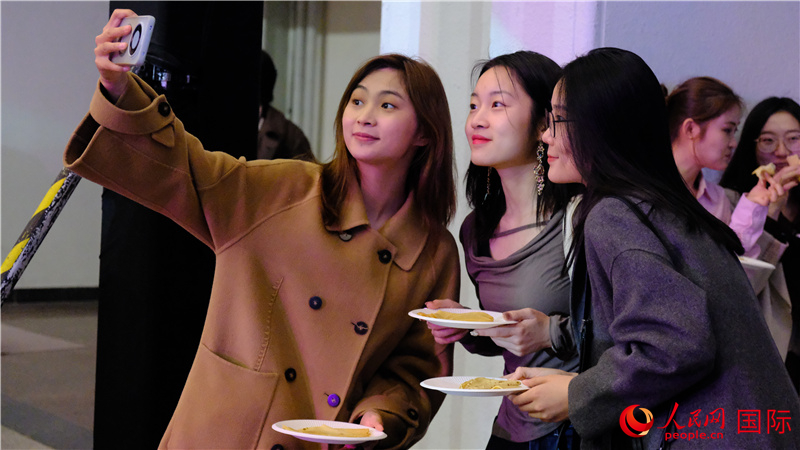 中國觀眾在現(xiàn)場品嘗“謝肉節(jié)”節(jié)日美食——煎薄餅。人民網(wǎng) 褚夢琦攝