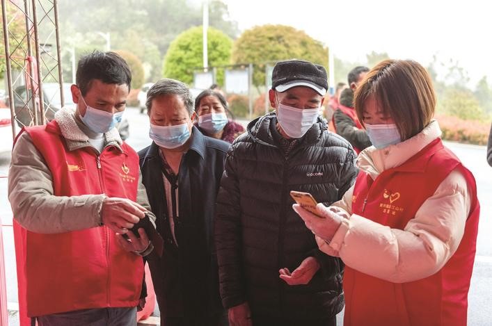 長沙縣黨員志愿者正在幫助參與核酸檢測的群眾掃描“場所碼”。劉思源 攝