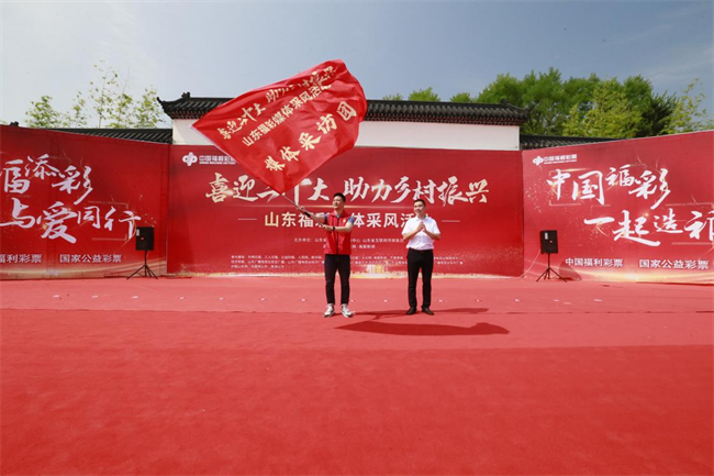 為媒體采風(fēng)團(tuán)授旗。 山東省福彩供圖