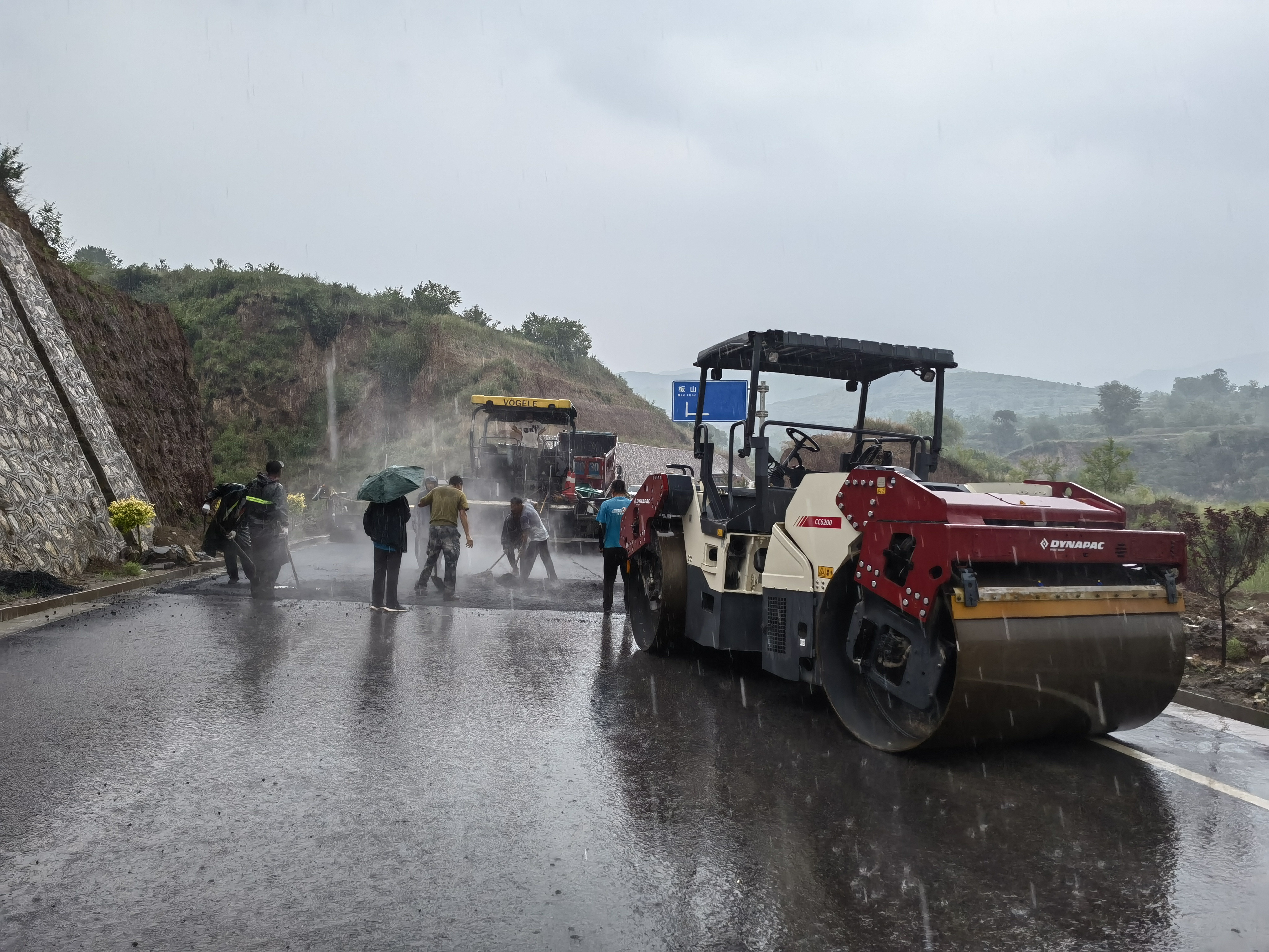 路橋工人在大雨中搶修道路。李華英 攝