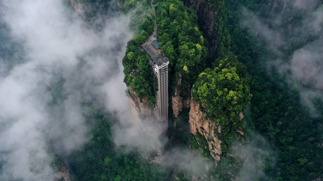 位于張家界武陵源景區(qū)的百龍?zhí)焯蓁偳对谠旗F繚繞的峰林間，雄偉壯觀。吳勇兵攝