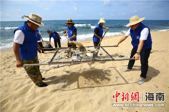 環(huán)保志愿者用篩網(wǎng)“淘”出海灘上的垃圾。
