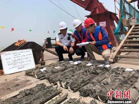 圖為勘察設計人員與海事局工作人員查看巖芯情況?！∥赫?攝