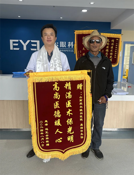 達(dá)瓦老人向吳四華（左）贈(zèng)送錦旗。受訪者供圖