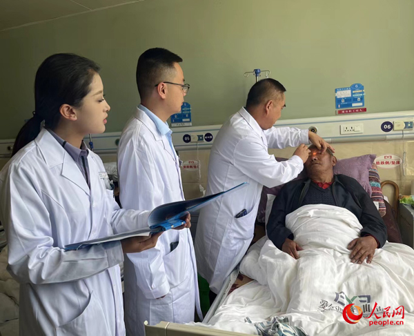 董光明（左三）帶領(lǐng)醫(yī)生對(duì)患者進(jìn)行術(shù)前檢查。人民網(wǎng)記者 杜燕飛攝