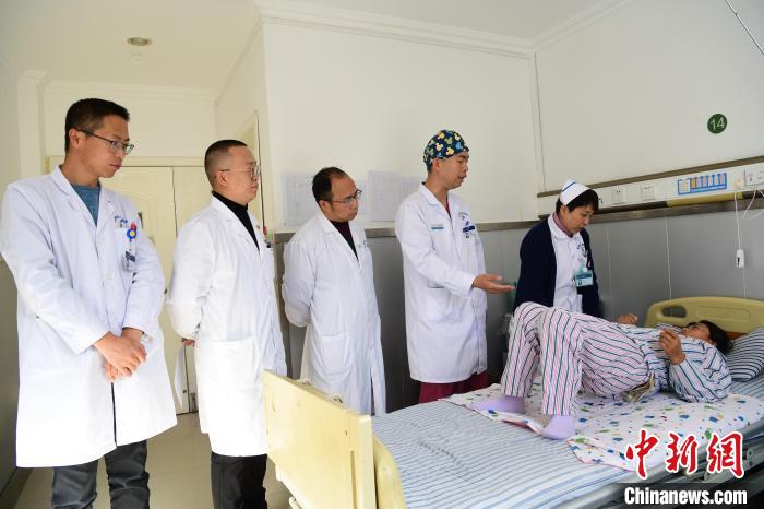 圖為何蔚副主任醫(yī)師(站右二)及團隊術(shù)后指導患者進行腰背肌鍛煉?！∝暩聛硭?攝