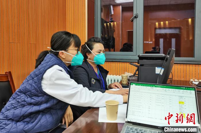 8月9日，楊蘇喬(左)在拉薩方艙醫(yī)院指揮部讀取艙內(nèi)患者胸部CT?！∈茉L者供圖