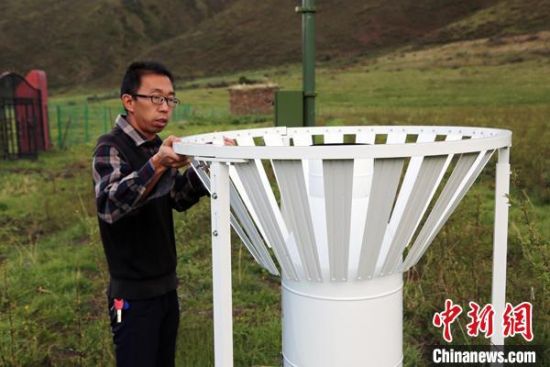圖為班瑪縣氣象局工作人員在維護(hù)藏雪茶基地氣候站。青海省氣象局供圖