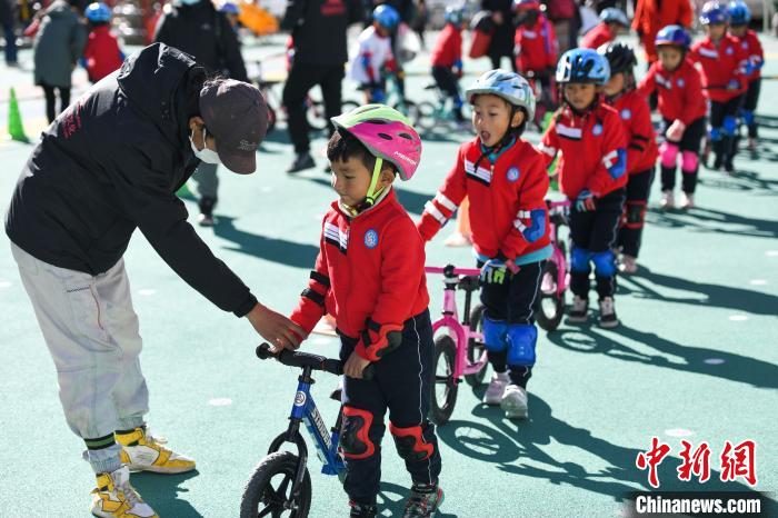 圖為拉薩市實(shí)驗(yàn)幼兒園孩子們在教練的指導(dǎo)下練習(xí)滑步車?！『闻罾?攝