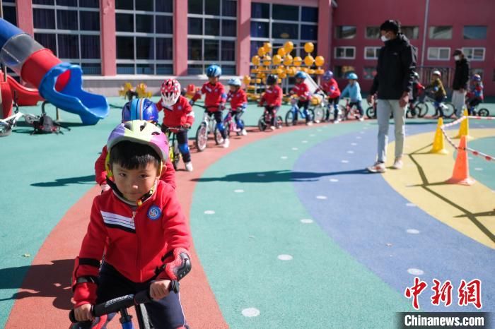 圖為拉薩市實(shí)驗(yàn)幼兒園孩子們在教練的指導(dǎo)下練習(xí)滑步車?！『闻罾?攝
