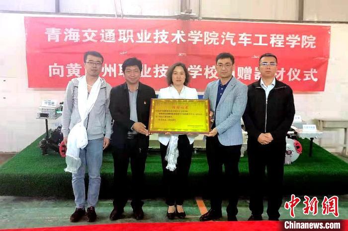 圖為李富香(中)代表學(xué)校為州縣技校捐贈(zèng)器材。(資料圖) 青海省教育廳供圖
