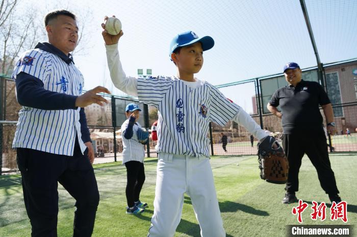 圖為教練指導(dǎo)小棒球手?jǐn)S球技術(shù)?！●R銘言 攝