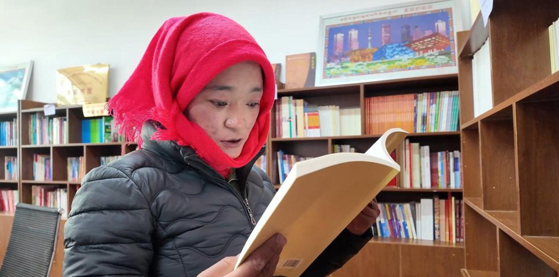一名婦女正在認(rèn)真閱讀書(shū)籍。申扎縣融媒體中心供圖