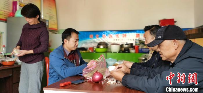 圖為扶貧路上“臨時一家人”準(zhǔn)備午餐?！∥航ㄜ?攝