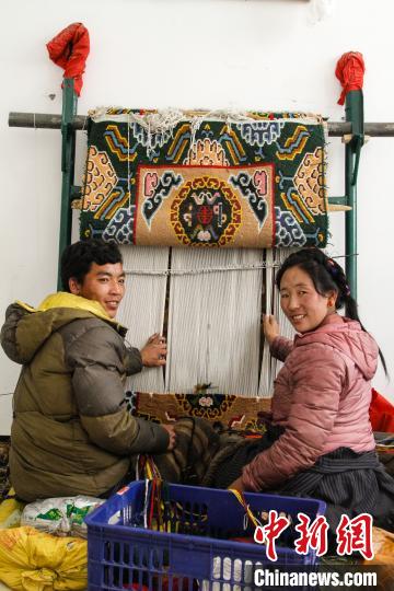 圖為1月15日，在日喀則市謝瑪氆氌農(nóng)村合作社，拉孜村一對夫婦在編織卡墊(資料圖)?！≮w朗 攝