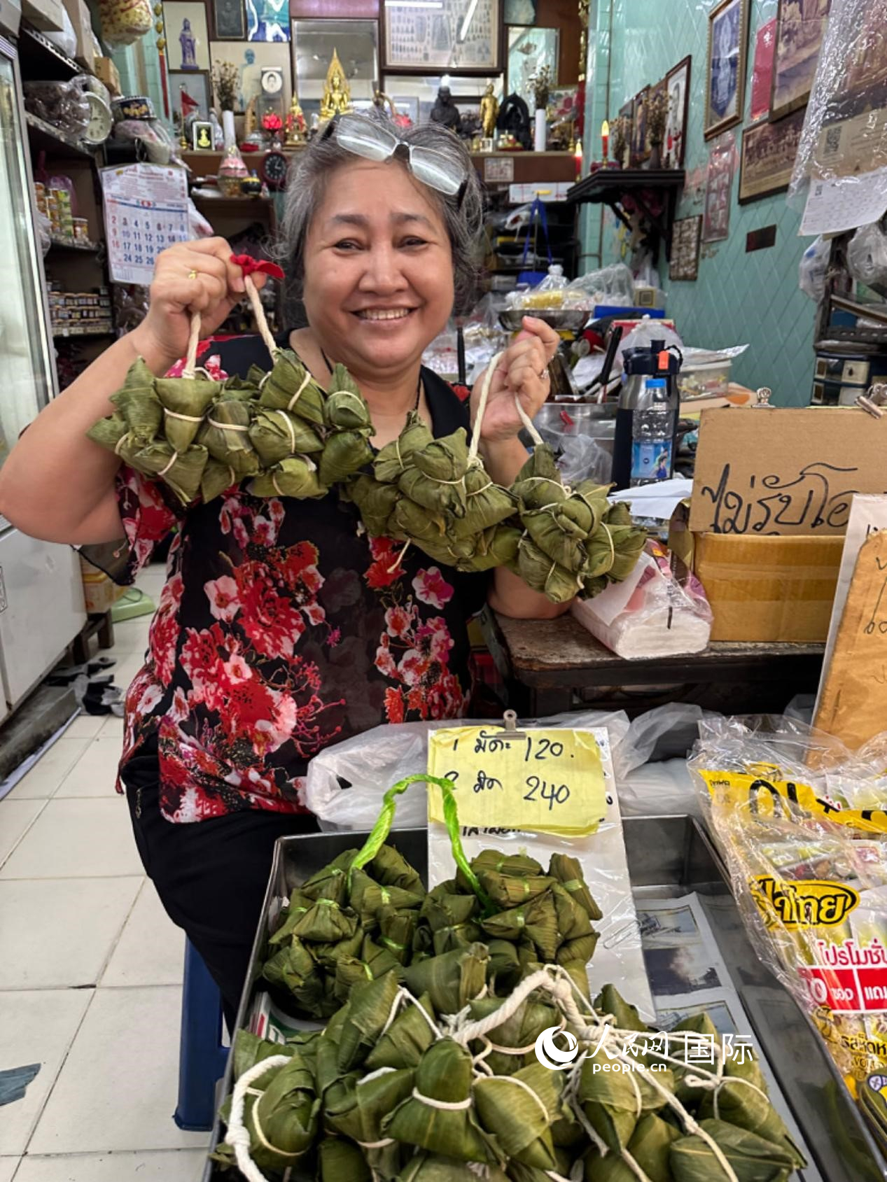 商家向顧客介紹“吉掌”（粽子的一種，一串一串，個(gè)頭較?。?。人民網(wǎng)記者 簡(jiǎn)承淵攝