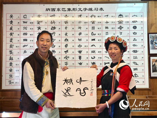 人民網(wǎng)“行進中國”云南調研采訪團走進麗江，和閏元現(xiàn)場用東巴文寫下“行進中國”。人民網(wǎng)記者 符皓攝