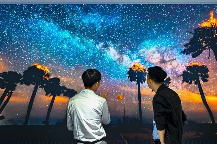 長春光博會希達電子展區(qū)，一位工作人員正在給一位觀眾講解。（長春新區(qū)供圖）