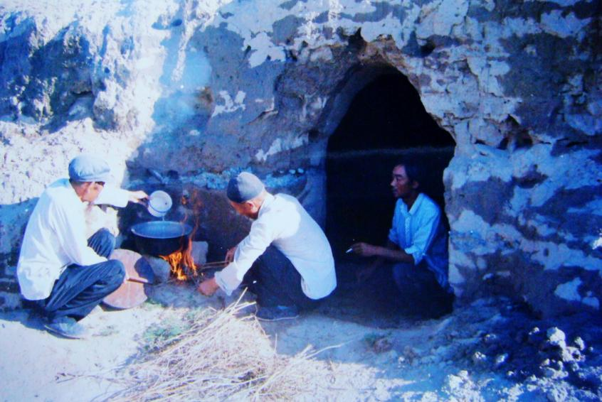 1983年，“六老漢”一代治沙人在“地窩子”生活做飯。新華社發(fā)（八步沙林場供圖）